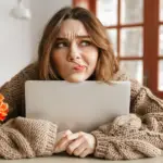 woman sat at a table looking confused