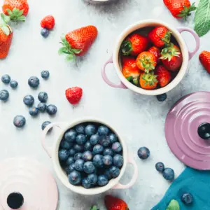 table with bowl of strawberries and blueberries