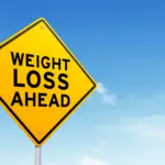 how to lose weight with adhd: yellow sign against blus sky that reads "weight loss ahead"