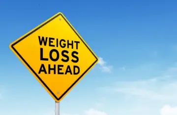 how to lose weight with adhd: yellow sign against blus sky that reads "weight loss ahead"